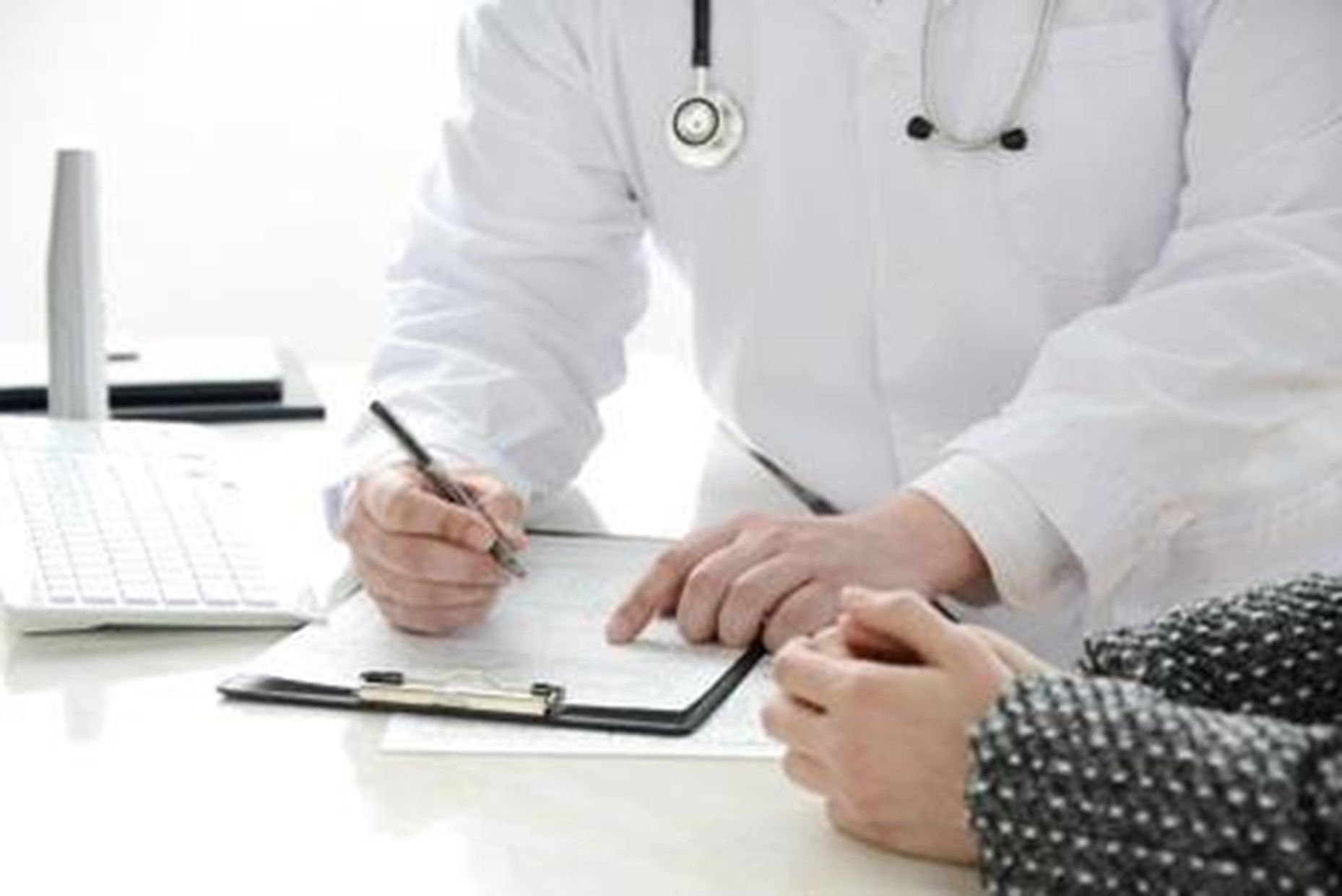Doctor filling out a form with a patient with zoom in the form