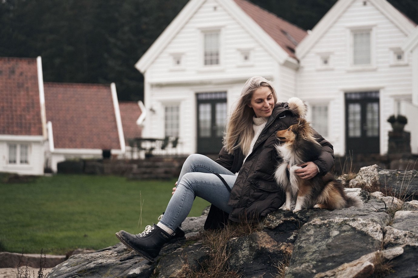 Female patient sitting on a rock hugging her dog