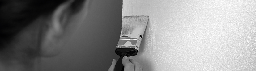 Close up on a person painting a wall