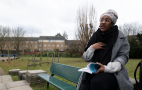 Picture of a person living with a severe disease reading a book in  a park