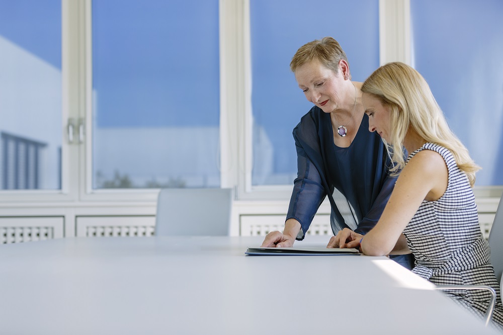Two women reviewing a document in an office.