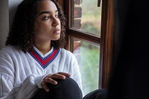 Picture of a young lady looking outside the window