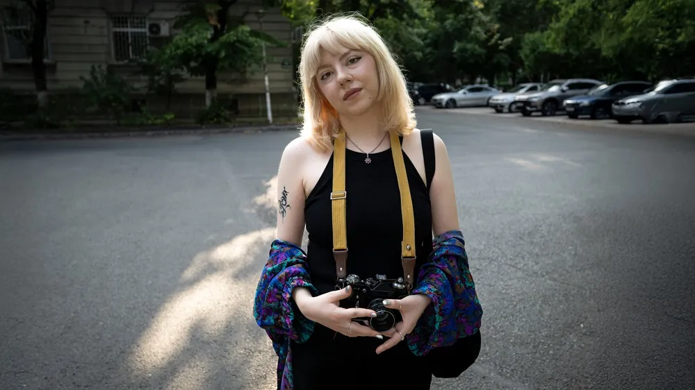 Picture of Alisa living with myasthenia gravis holding a camera