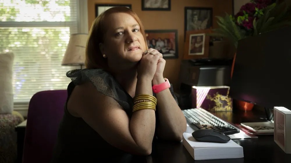 Picture of Allison, Executive Director for the Myasthenia Gravis Association, living with myasthenia gravis seated at her desk